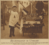 871413 Afbeelding van een jongetje verkleed als visventer bij een karretje met het opschrift 'Haring Zuur-A. de Nijs', ...